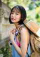 A young woman wearing a straw hat and a backpack.