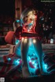 A woman sitting on a blanket in front of a Christmas tree.