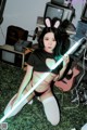 A woman in bunny ears holding a light saber.