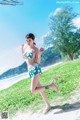 A woman in a bikini running on the beach.