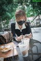 A woman sitting at a table with a cup of coffee and a phone.