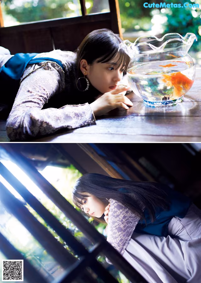 A woman laying on a window sill next to a fish bowl.