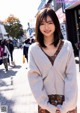 A woman standing in the middle of a city street.