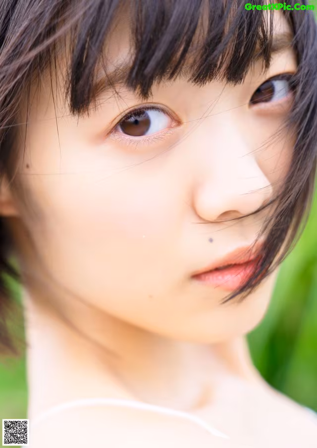 A close up of a woman's face with long black hair.