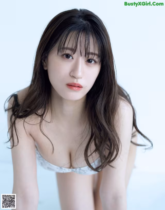 A woman in a white bra and panties posing for a picture.