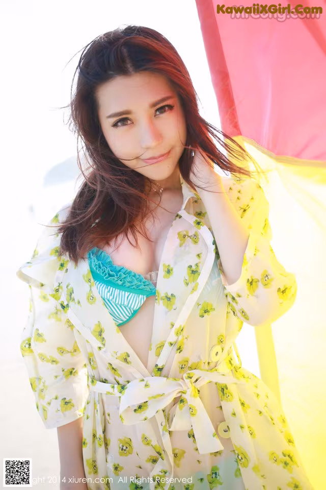 A woman in a yellow dress posing for a picture.