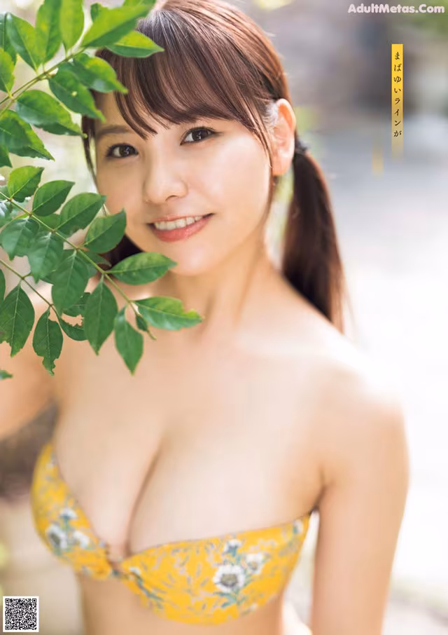 A woman in a yellow bikini posing for a picture.