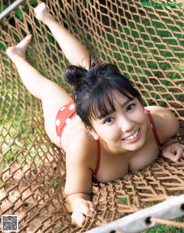 A woman in a red bikini laying in a hammock.
