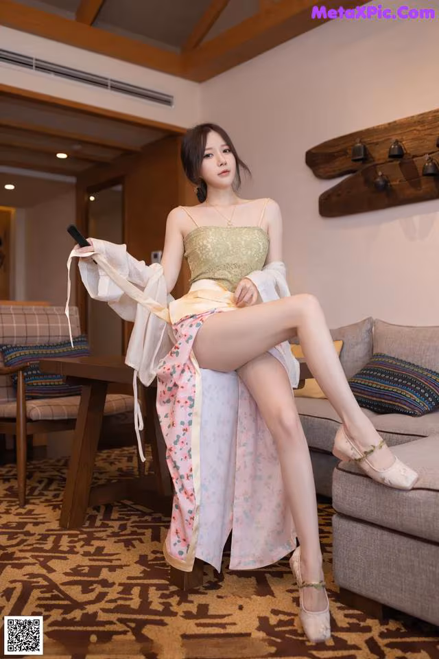 A woman sitting on a couch holding a cell phone.