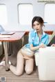 A woman sitting on a couch next to a table with a laptop.